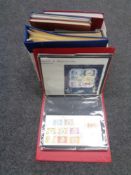 A box containing folders and albums of stamps of the world.