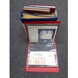 A box containing folders and albums of stamps of the world.