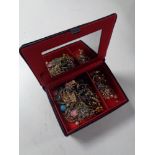 A contemporary velvet jewellery box containing costume jewellery to include beaded necklaces,