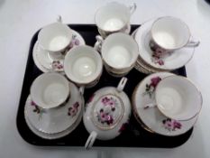 A tray containing 33 pieces of English pink rose patterned bone tea china.