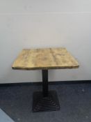 A pine square topped cafe table on Art Deco style metal pedestal