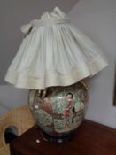 A bulbous Japanese style table lamp with shade depicting geishas.