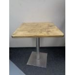Eight square pine topped cafe tables on metal pedestals