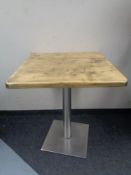 Eight square pine topped cafe tables on metal pedestals