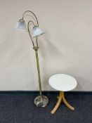 A contemporary circular occasional table together with a brass floor lamp with shades