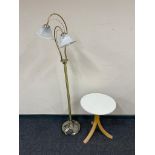 A contemporary circular occasional table together with a brass floor lamp with shades