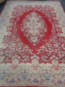 A large fringed floral carpet on red ground