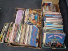 Four boxes containing a large quantity of vinyl LPs and 45 singles to include World Music