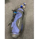 A golf bag containing five assorted drivers to include Triumph and Dunlop,