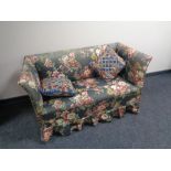An early 20th century settee upholstered in a floral fabric together with two scatter cushions