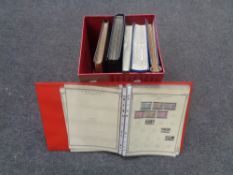 A box containing folders and albums of stamps of the world.