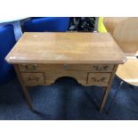 A oak three drawer lowboy with brass drop handles