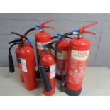 Seven various fire extinguishers.
