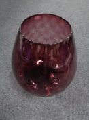 A purple glass vase in the form of a brandy glass,