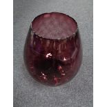 A purple glass vase in the form of a brandy glass,