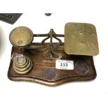 A set of brass postal scales with weights.