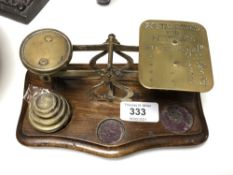 A set of brass postal scales with weights.