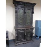A 19th century profusely carved continental oak hunting cabinet with leaded glass doors and