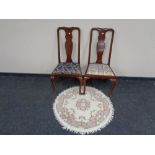 A pair of mahogany Queen Anne style dining chairs together with a circular fringed Indian rug.