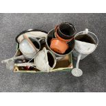 A box containing three galvanized watering cans together with a quantity of plastic plant pots.