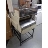 A Delta commercial bread slicer on stand.