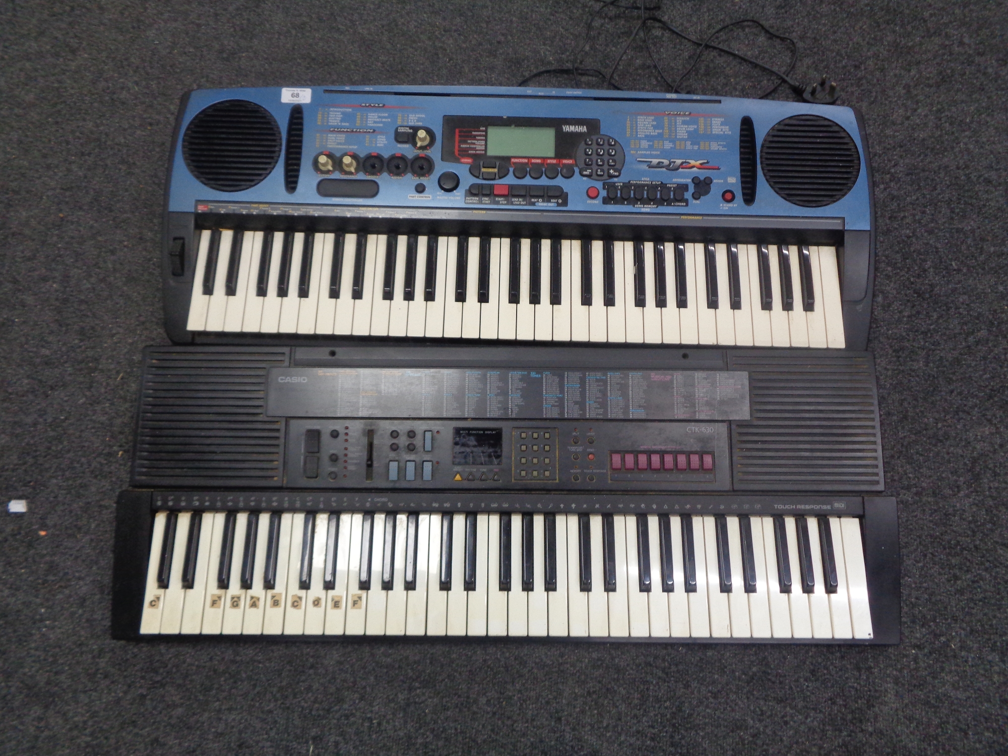 A Yamaha keyboard with power lead, and a Casio keyboard, lacking lead.