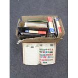 A box containing folders and albums containing 20th century stamps of the world.