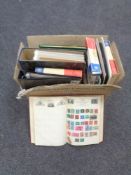 A box containing folders and albums containing 20th century stamps of the world.