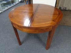 A circular pine extending dining table fitted a leaf