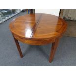 A circular pine extending dining table fitted a leaf