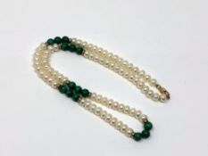 A pearl necklace with gold spacers and clasp.