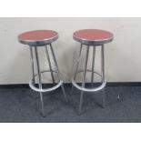 Four circular aluminium bar stools.