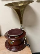 A reproduction HMV tabletop gramophone with brass horn.
