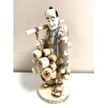 A Japanese carved bone and penwork okimono, travelling basket seller,