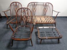 A four piece Ercol elm and beech lounge suite in an antique finish comprising of two seater settee,