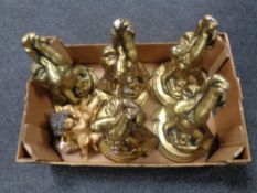 A box containing five gilt cherub wall shelves together with two further cherub figures.