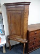 A George III oak corner cabinet on later stand