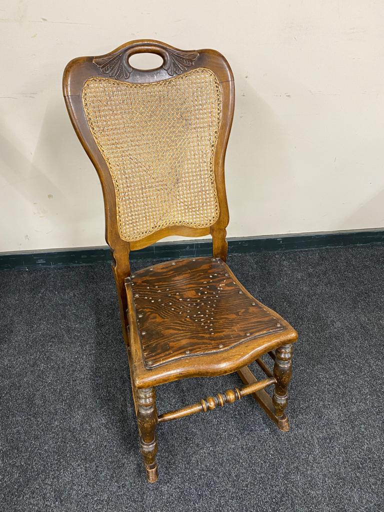 An early 20th century beech bergere rocking chair