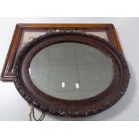 An antique oval composite framed mirror together with a further framed antique mirror with two