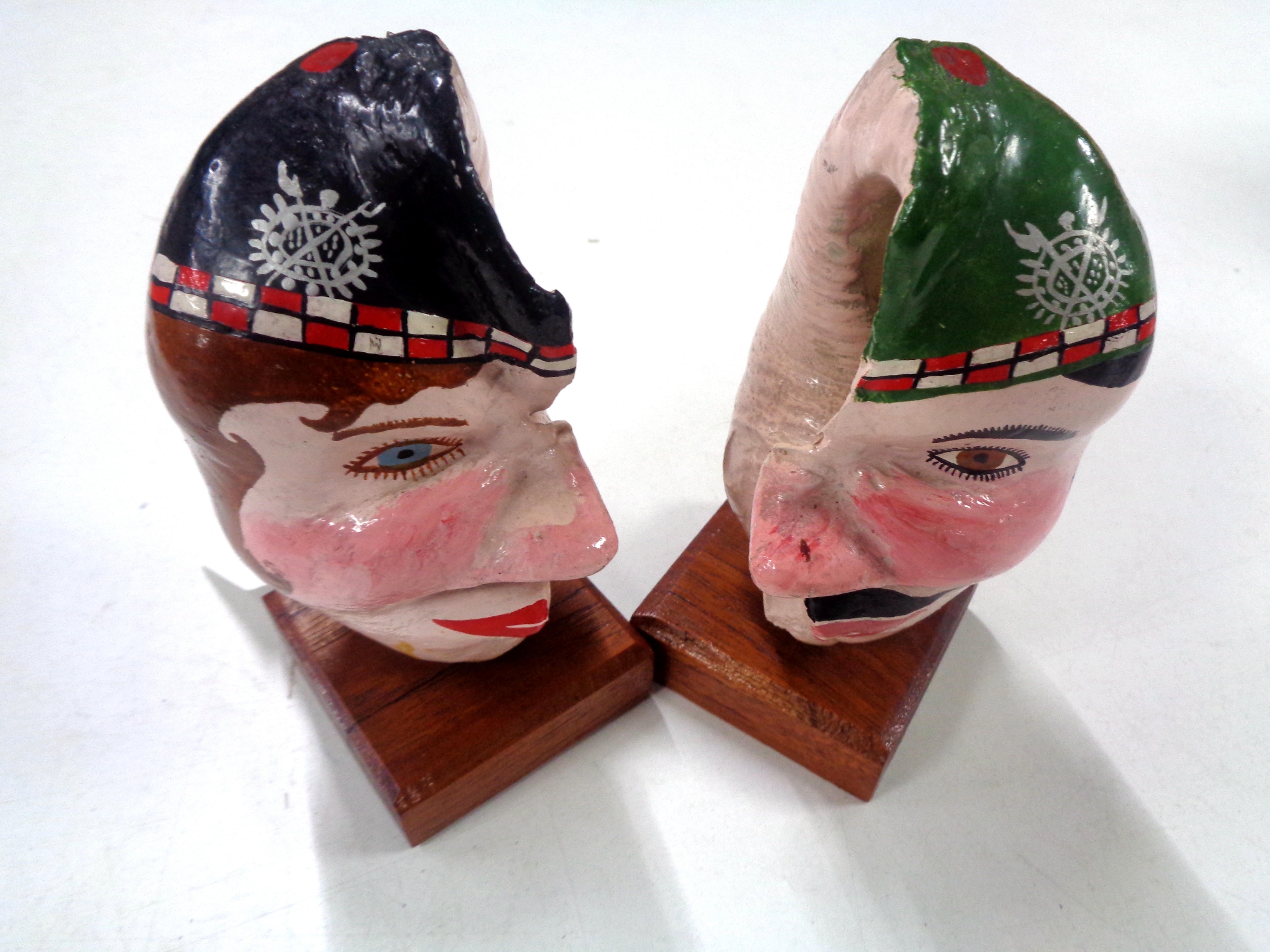 An unusual pair of hand painted shells mounted on wooden plinths, height 15 cm.