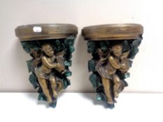 A pair of painted chalk cherub wall shelves.