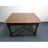 An Edwardian oak extending dining table on barley twist legs