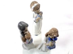 Three Nao figures, girls with dolls.