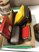 A box containing a collection of vintage cigarette and cigar tins.