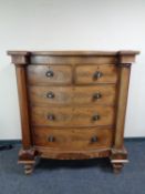 A Victorian mahogany bowfronted five drawer chest with pillar column supports