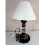 A Moorcroft table lamp, violets, on green ground, on wooden base,