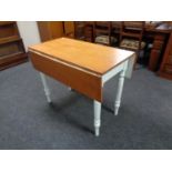 An antique pine drop leaf kitchen table on painted legs
