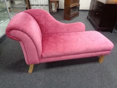 A contemporary chaise longue upholstered in pink fabric