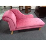 A contemporary chaise longue upholstered in pink fabric