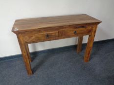 A sheesham wood side table, fitted two drawers.